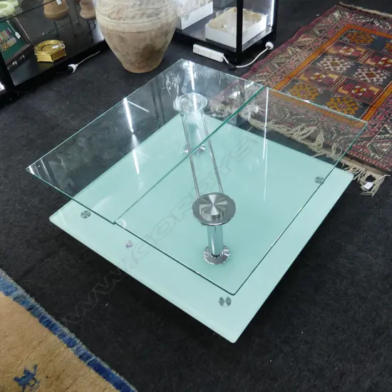 LARGE SQUARE GLASS TWO LEVEL COFFEE TABLE. TWO GLASS PANELS AT TOP SWIVEL TO REVEAL LOWER LEVEL. SQ 850 H. 370mm