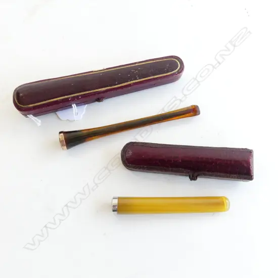 TWO ANTIQUE CIGARETTE HOLDERS W. CASES LABELED “COMOY’S FINEST AMBER LONDON MADE” & “STERLING SILVER MTD” L. 125MM & 90M