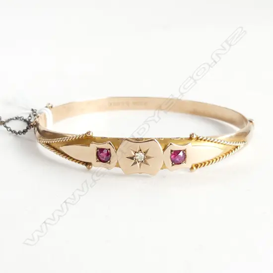 9CT GOLD BANGLE WITH 2 RUBIES AND CENTRAL DIAMOND. 8GMS faults