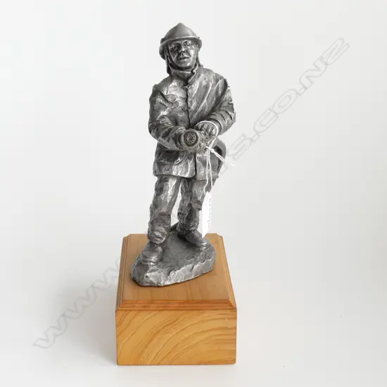 PEWTER FIGURE OF FIREMAN WITH HOSE INITIALED GM HEIGHT ON WOOD BASE 270MM
