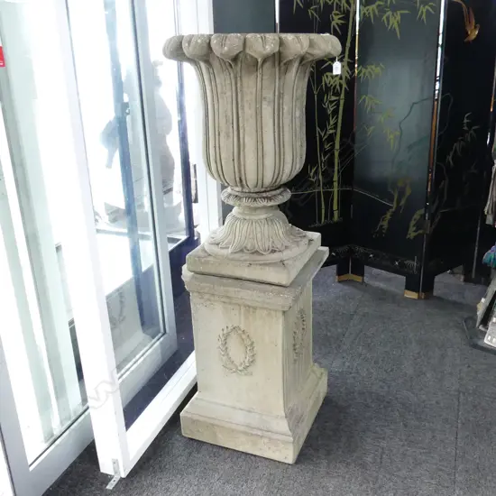 FLUTED CONCRETE URN H.690mm ON PLINTH. H.600mm.  (2 corners of plinth chipped)