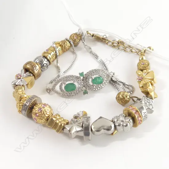 2 BRACELETS; 1 WITH EMERALDS & 1 WITH CHARMS