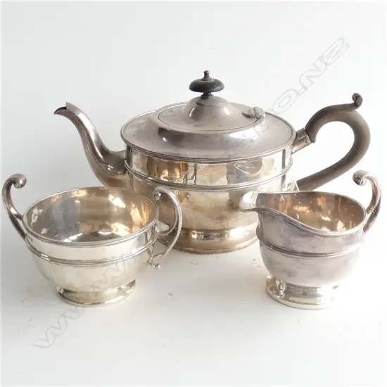 A three piece silver tea set of circular section,