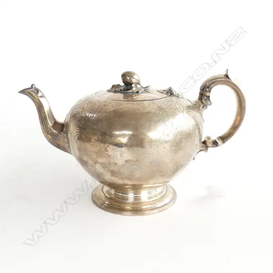 An early Victorian silver teapot the ovoid body with scroll engraved decoration