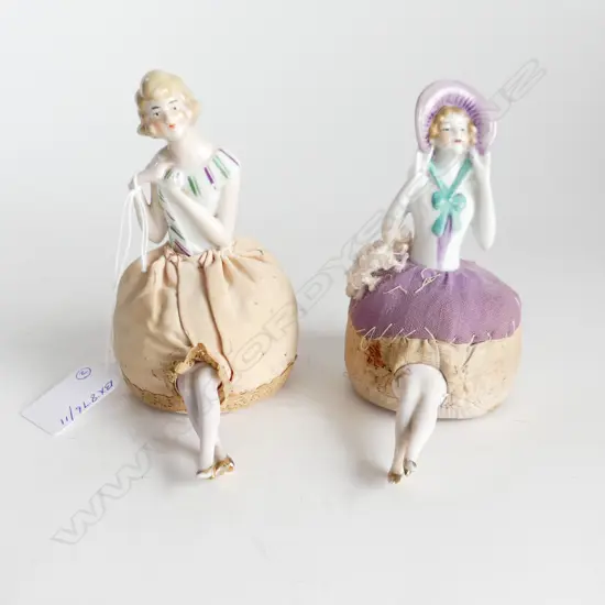 TWO ANTIQUE HALF DOLL PIN CUSHIONS WITH LEGS – ONE WITH BONNET, ONE WITH PURPLE & GREEN COLLAR H. 120mm