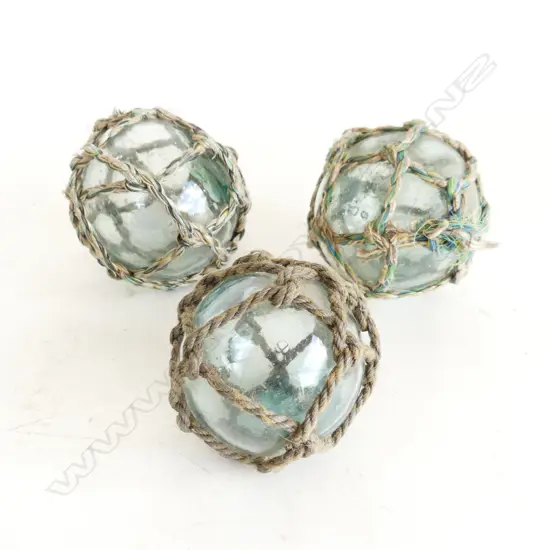 THREE SMALL VINTAGE JAPANESE GLASS FISHING FLOATS WITH GLASS SEALS AND ROPE WORK D. 7CM -8.5CM