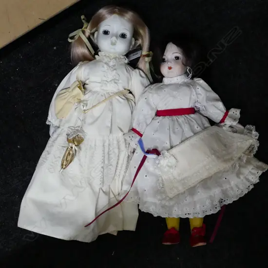 2 PORCELAIN HEADED DOLLS ONE ON STAND WITH PIGTAILS.