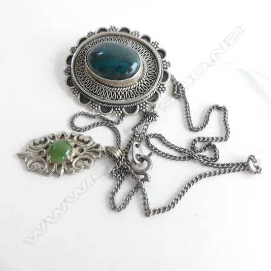 2 SILVER PENDANTS WITH GREEN STONES; BOTH ON SAME CHAIN