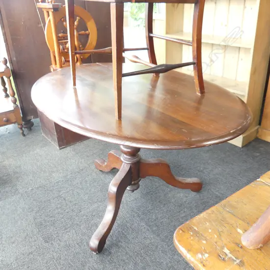 C 1900 RIMU OVAL SHAPED TILT TABLE. TURNED CENTRAL SUPPORT ON THREE SPLAY LEGS. SPLIT TO TOP NEEDS ATTENTION. H.730mm