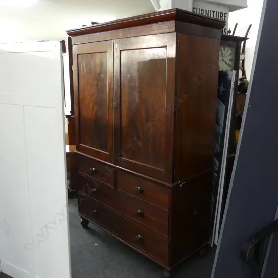 GEORGE III MAHOGANY LINEN PRESS. FLAME PANELLED TOP WITH 5  SLIDING SHELVES. 4 DRAWER BASE ON TURNED FEET. H.2050 W1380