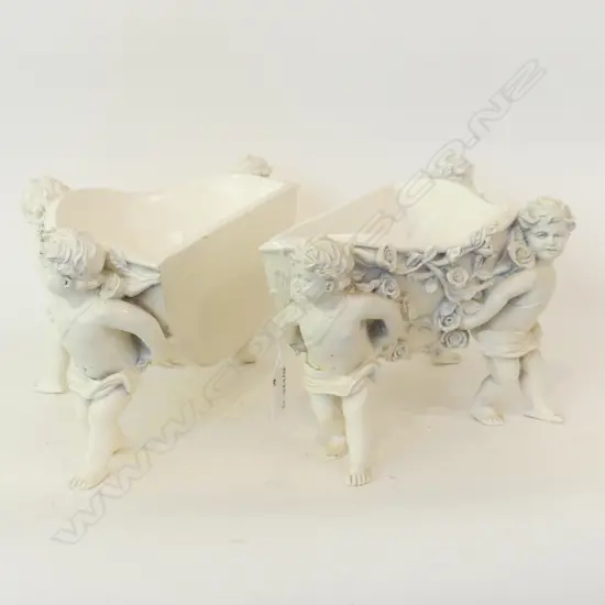 PR OF WHITE PORCELAIN CONTAINERS EACH SUPPORTED BY 3 CHERUBS L 300MM