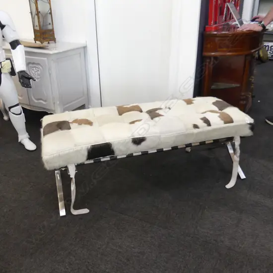 BARCELONA LONG STOOL PATCHWORK COW HIDE COVERED STAINLESS X FRAME minor rust marks. L. 1200MM