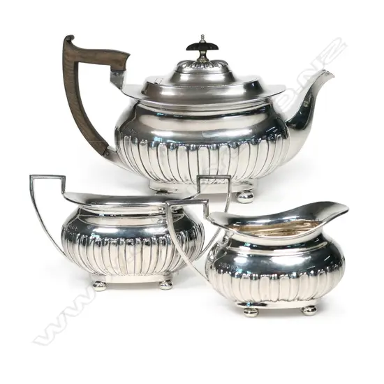 A Victorian silver three-piece tea set with squat circular oblong half-lobed body raised on ball feet. Sheffield 1897 by Walker &Hall. Total 1177gm.