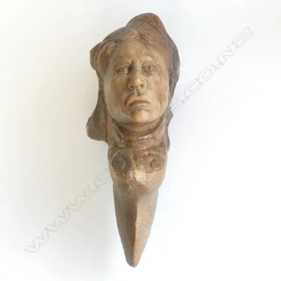 An old tree trunk section carved with the bust of a woman