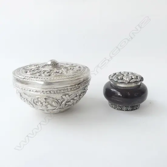 TWO EASTERN SILVER LIDDED TRINKET BOWLS, ONE HEAVILY EMBOSSED, ONE WITH PURPLE GLASS, D.90MM & D.50MM
