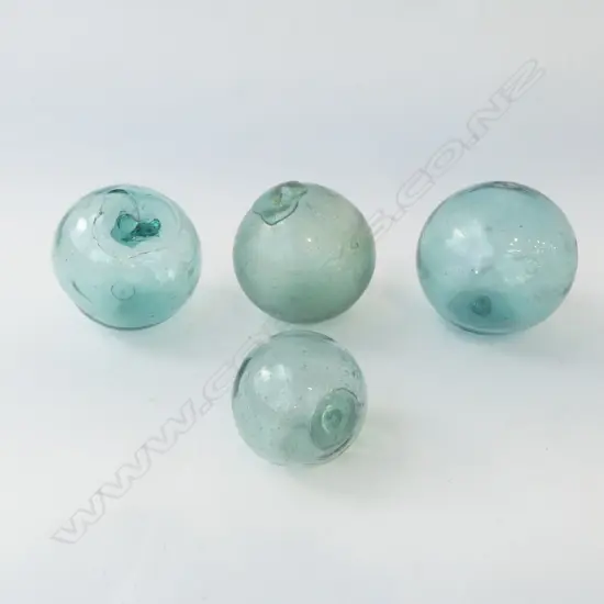 FOUR SMALL VINTAGE JAPANESE GLASS FISHING FLOATS WITH GLASS SEALS. D.65MM-90MM