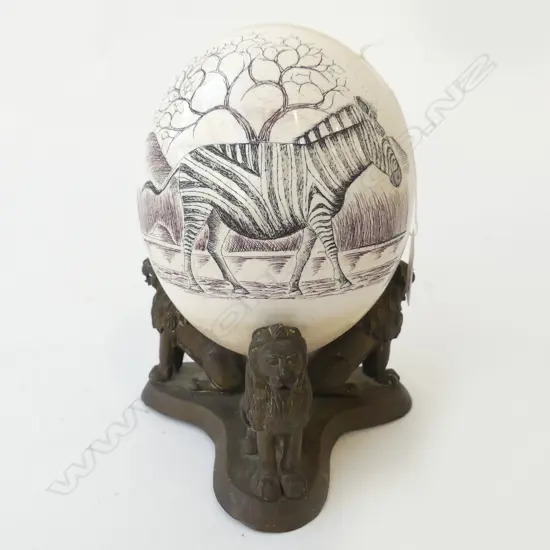 OSTRICH EGG WITH ZEBRA DECORATION ON A BRONZE LION BASE H 210 MM