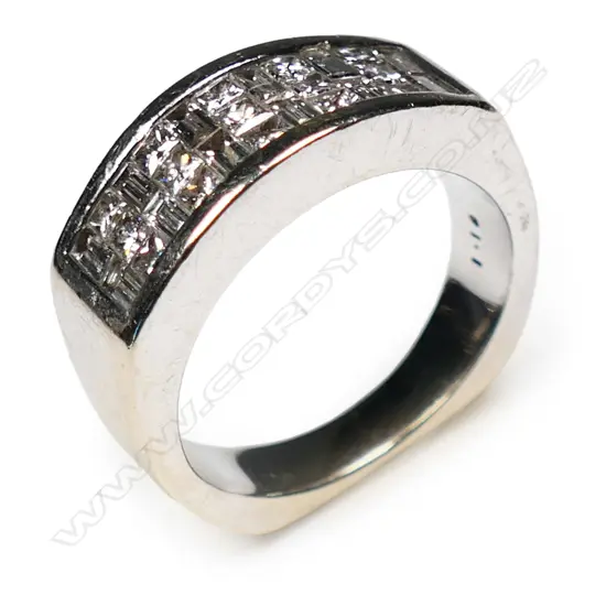 An 18ct white gold and diamond ring channel set with twelve baguette cut and fifteen round brilliant cut diamonds.  10.4gms,