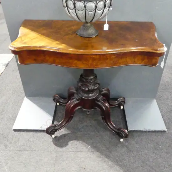 A Victorian walnut card table, shaped top, green baize, raised on ornate quadruped base with porcelain casters. 860 x 460 x 765mm.