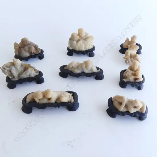 8 small ORIENTAL CARVED STONE FIGURES in fitted wooden carved bases.