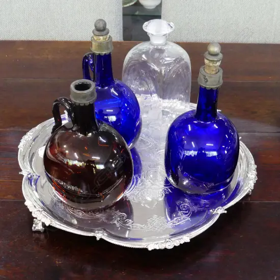4 VINTAGE GLASS STOPPERED BOTTLES, 2 BRISTOL BLUE ON A SCALLOPED EDGED SILVER PLATED TRAY