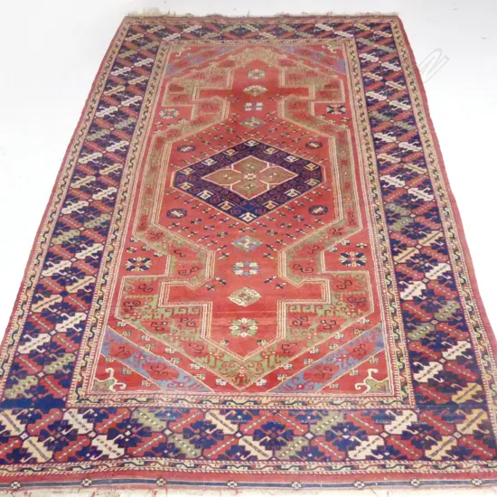 LARGE HANDKNOTTED WOOL PILE RUG. CENTRAL TERRACOTTA FIELD WITH CENTRAL MEDALLION AND BLUE TONES. 2500X1700mm