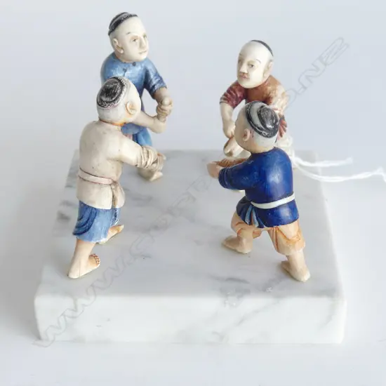 FOUR COLOURED IVORY MOUNTED FIGURES ON MARBLE PLINTH L.10CM