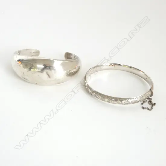 2 SILVER BANGLES: 1 HINGED THE OTHER AS A PUFF CUFF. Minor dents