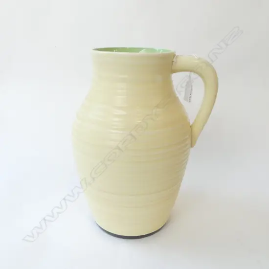 LARGE CLARICE CLIFF LOTUS JUG single handled. Ribbed design plain cream green to interior rim H.300mm