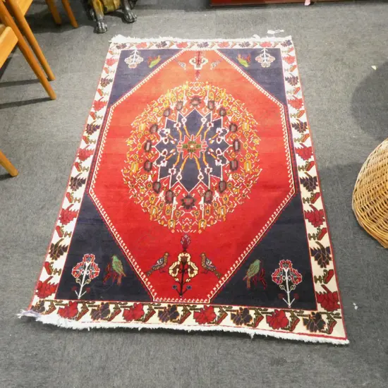 **RTV** PERSIAN QASHQAI WOOL PILE RUG; Central medallion on red ground w. bird motifs to each end 1450x1050mm