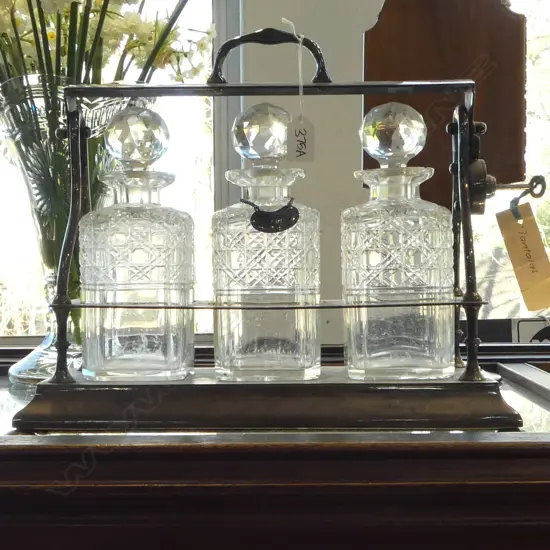 EARLY 20thC SILVER PLATE 3 BOTTLE TANTALUS. Half cushion cut. With key. 1 bottle w 1 chip. 495 x 330mm