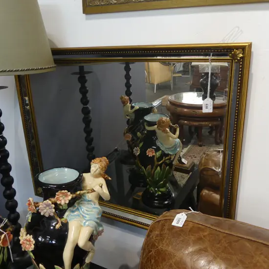 A CLASSICAL STYLE RECTANGULAR GILT MIRROR WITH FLEUR DE LYS CORNER INSERTS AND GLASS BEVEL 570 X 770 MM