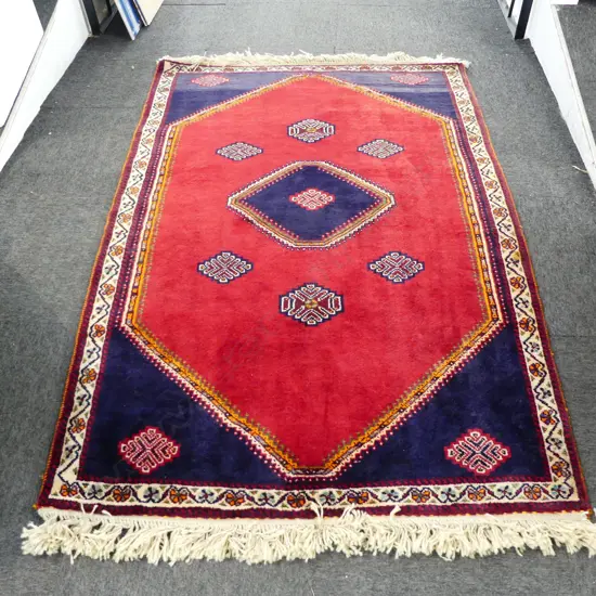PERSIAN QASHQAI ALL WOOL RUG; 6 central medallions on plain red lustre ground 1830x1130mm