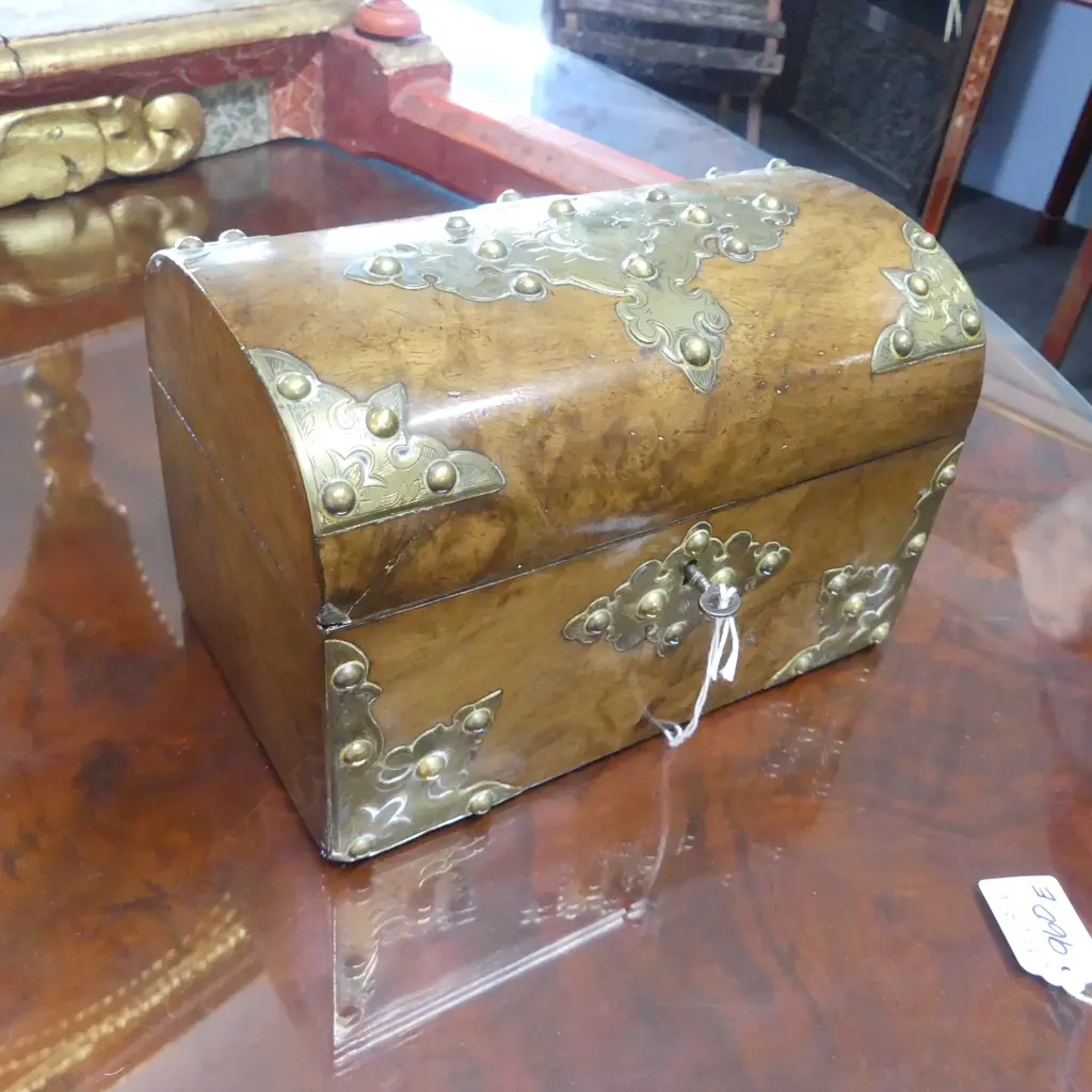 A Victorian walnut tea caddy of domed chest form with engraved and pierced brass decoration, the interior with silk lining to lid and two lidded compartments. Old repairs, with key. 210 x 130 x 145mm. Image 1++