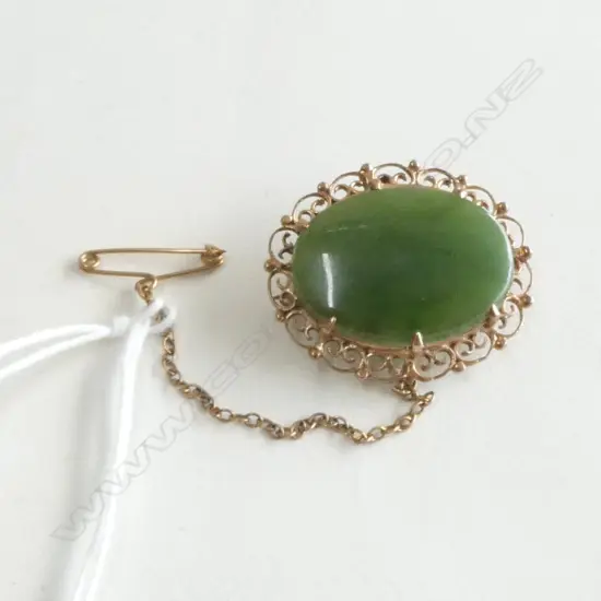 9ct GOLD FRAMED POUNAMU BROOCH scrolling frame 5.7gms. W.30mm