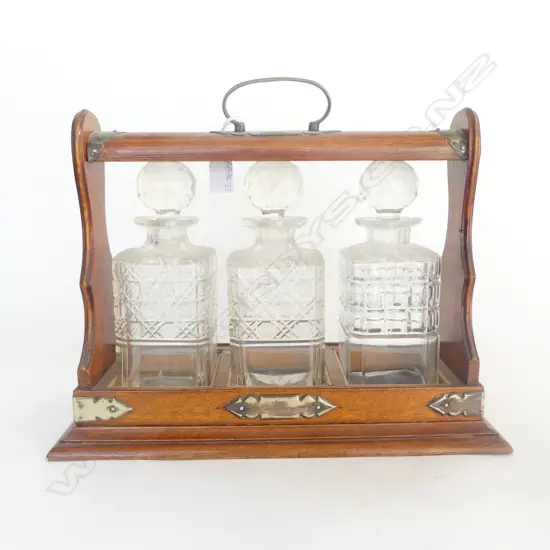EDWARDIAN OAK FRAMED TANTULUS with 3 CUT CRYSTAL DECANTERS some chipping to 2 RIMS s/plate fittings