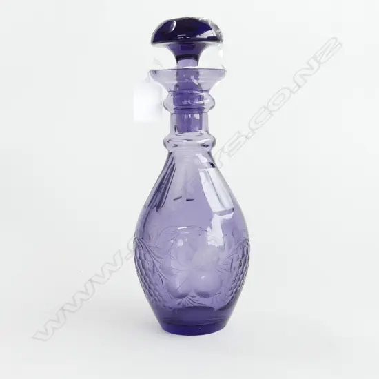 A purple decanter with cut grape decoration,