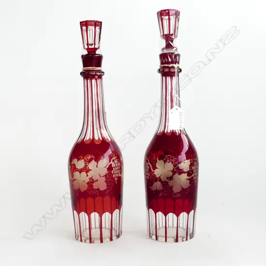 Two red glass decanters with red crystal grape overlay decorations,