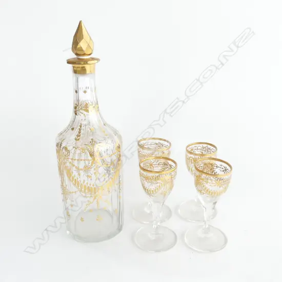 A gilded decanter with four matching glasses,