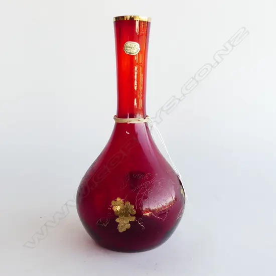 A red glass wine decanter with grapevine inlaid gold motifs,