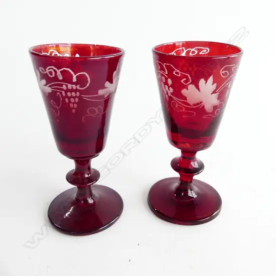 Two liqueur glasses overlaid with grape motifs,