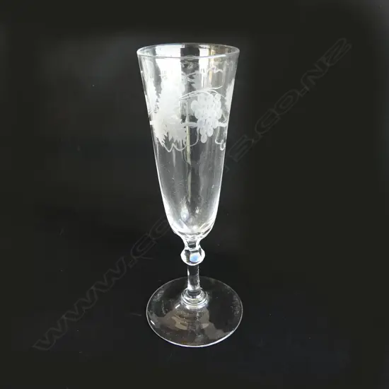 A champagne glass with grapevine etching,