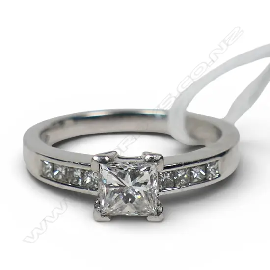 A platinum and diamond ring with a 0.50ct princess cut diamond channel set, with a further four small princess cut diamonds set to each shoulder. TDW. 0.80ct. Size M.
