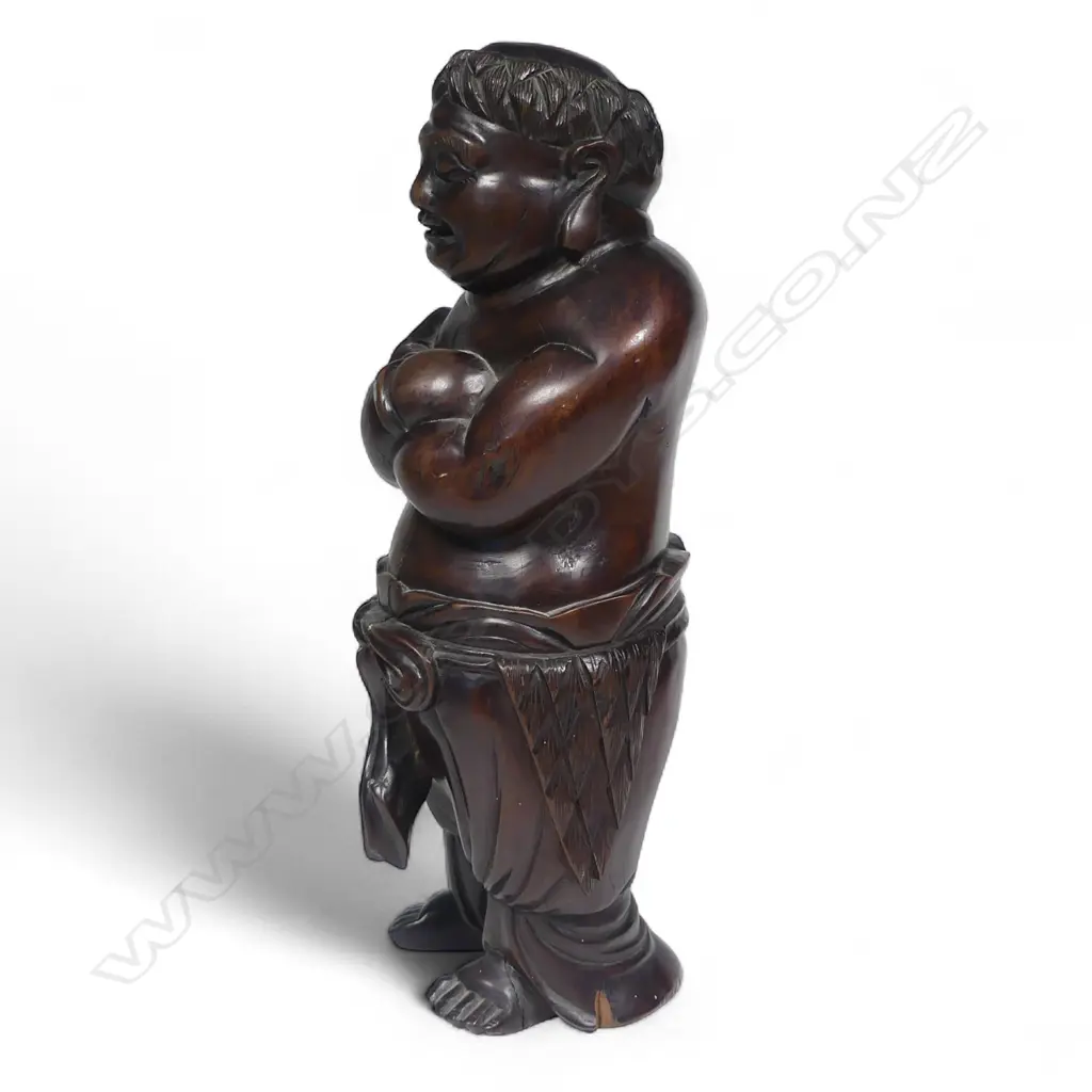 A 19thC Chinese carved hardwood Buddha figure standing with arms crossed wearing a drape around his waist. Old shrinkage crack to front and repair to foot. Good old patina. H.325mm. Image 1++