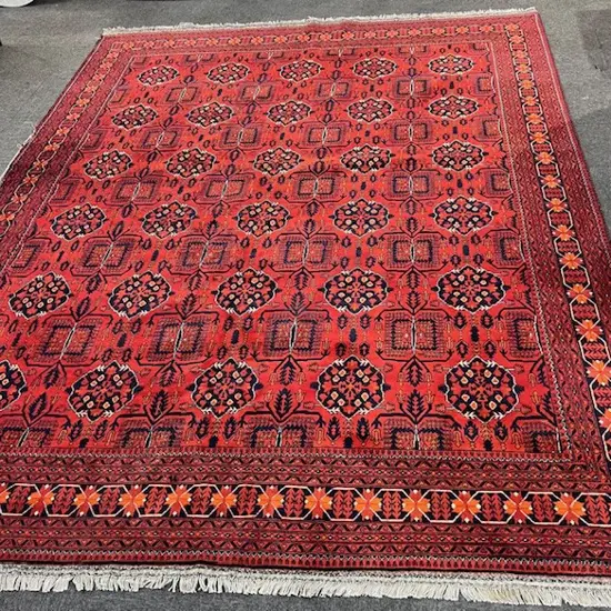 Very large Afghan Baluchi hand knotted carpet w repeating medallion design. Red ground. 3900 x 3000mm threads exposed