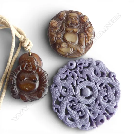 TWO CHINESE CARVED STONE BUDDHA PENDANTS AND A PURPLE CARVED STONE PENDANT WITH DRAGON DECORATION 