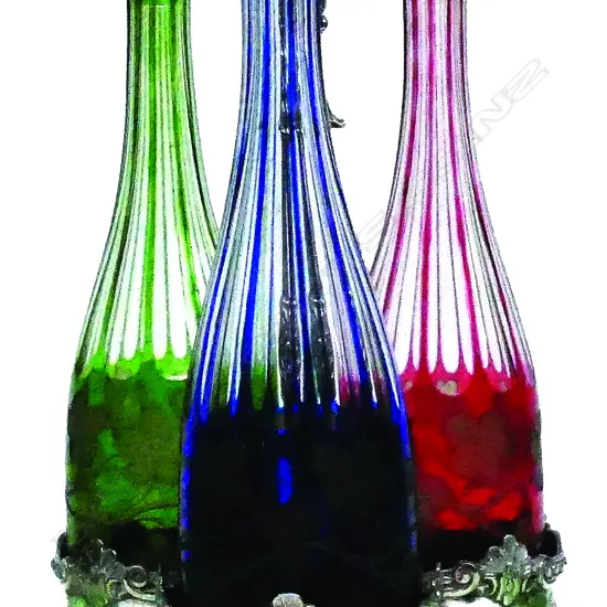 A 19thC silver plate and Bohemian three-bottle tantalus