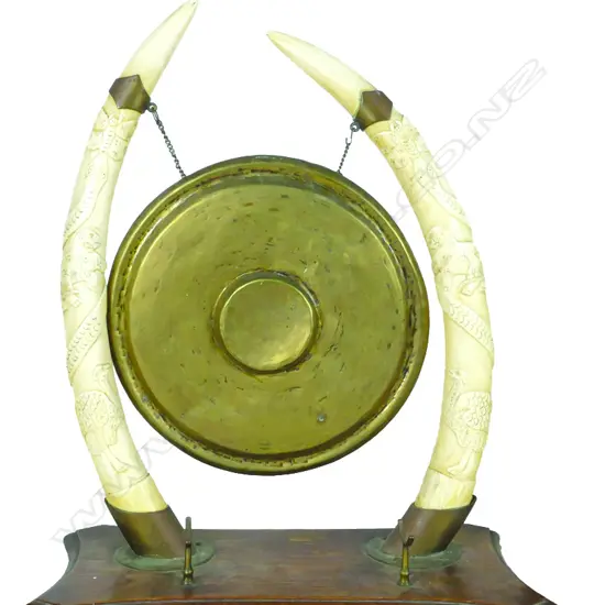 A dinner gong supported from ivory tusks