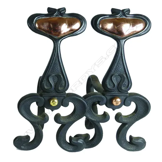 A pair of cast iron and copper Art Nouveau fire dogs