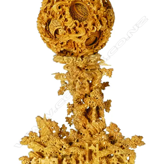 A fine carved boxwood puzzle ball on an intricately carved stand